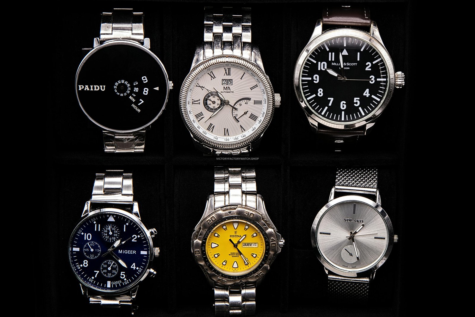 Collection of replica watches with different styles including chronograph, minimalist, and stainless steel designs in a display box
