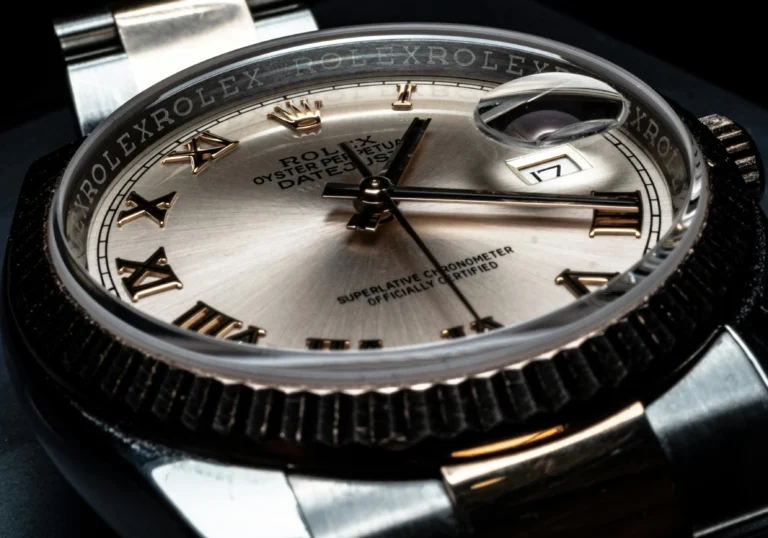 Close-up of a luxury Rolex Datejust watch dial with Roman numerals and magnified date window.