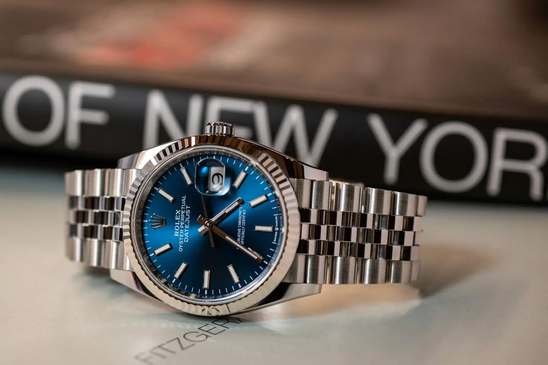 Blue dial Rolex Datejust style luxury watch with fluted bezel and jubilee bracelet displayed on surface