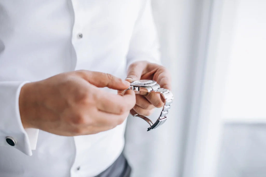 Man holding a Rolex Datejust inspired luxury watch, inspecting stainless steel bracelet and clasp quality